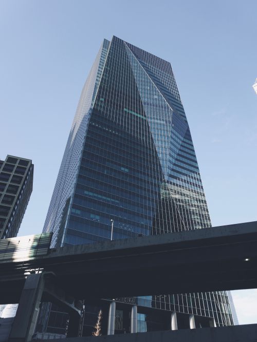 Free Modern skyscraper with reflective glass facade in Tokyo's urban skyline, under clear blue sky. Stock Photo