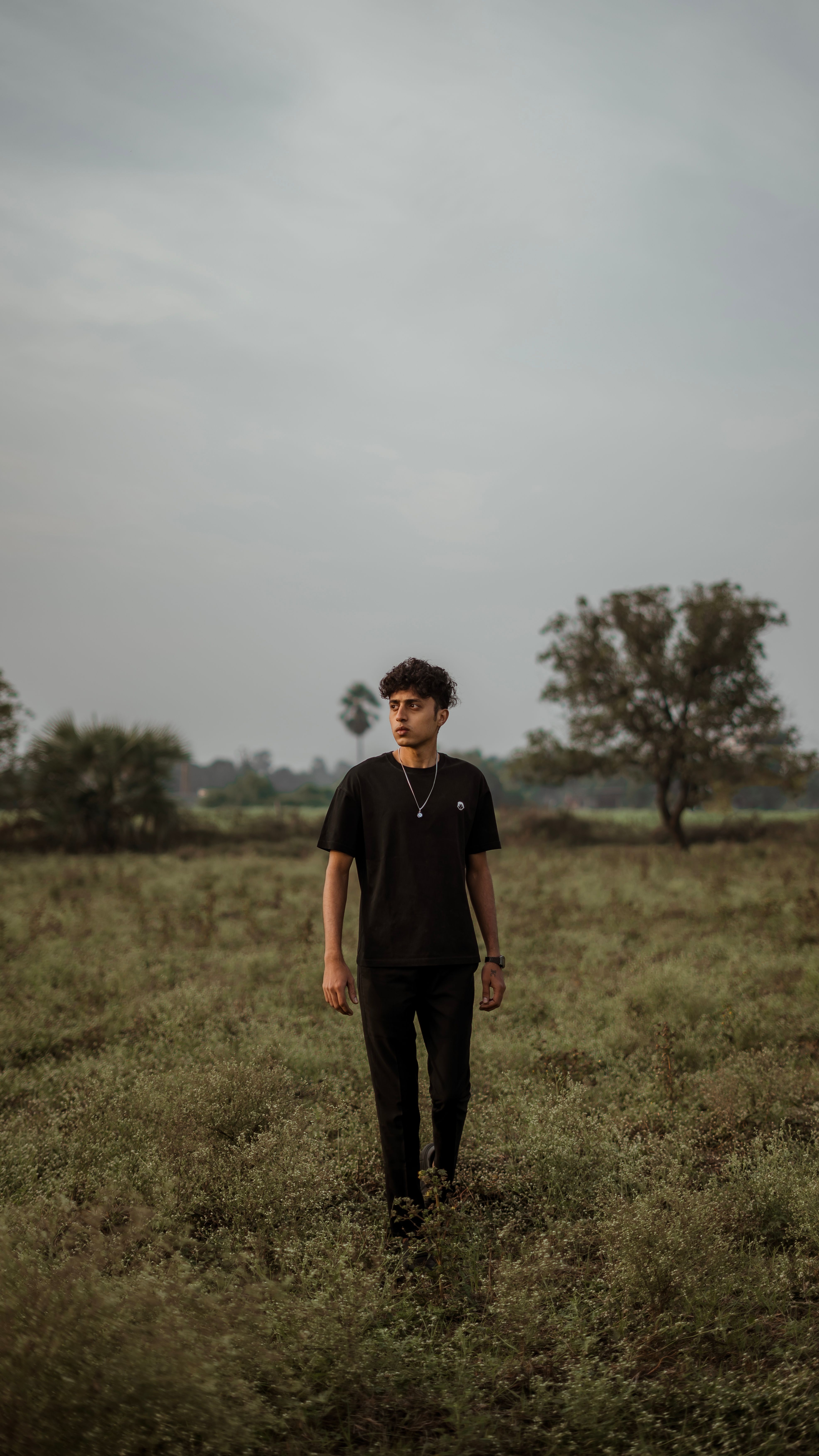 Man in Black Clothing Walking on a Meadow · Free Stock Photo