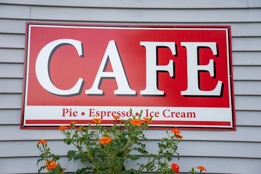 Colorful café sign with flowers, featuring pie, espresso, and ice cream offerings, in Stockholm, WI.