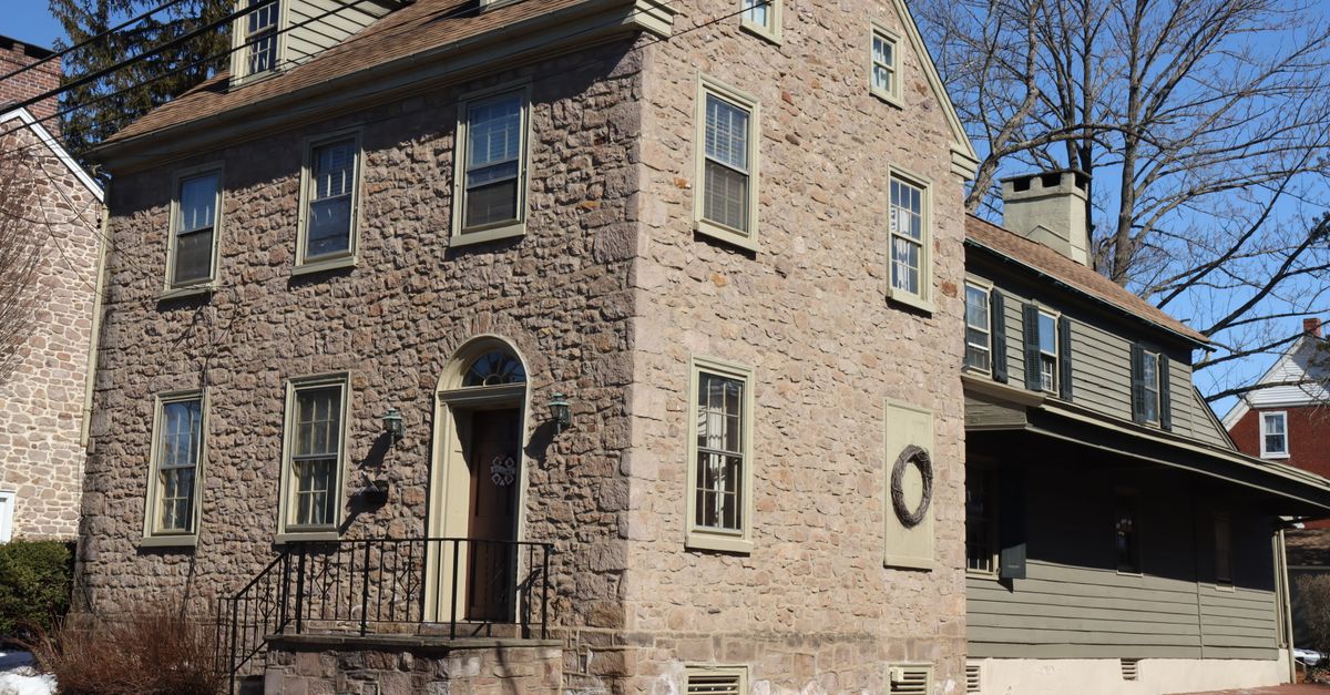 Charming stone house with colonial architecture in Newtown, PA on a sunny day.