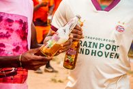 Two people holding Desperados beer bottles during a casual outdoor gathering.
