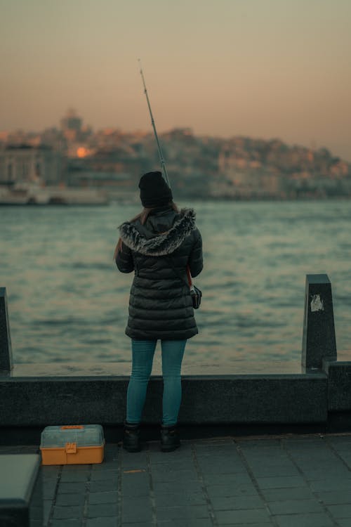Woman Fishing in the Sea at Dusk 