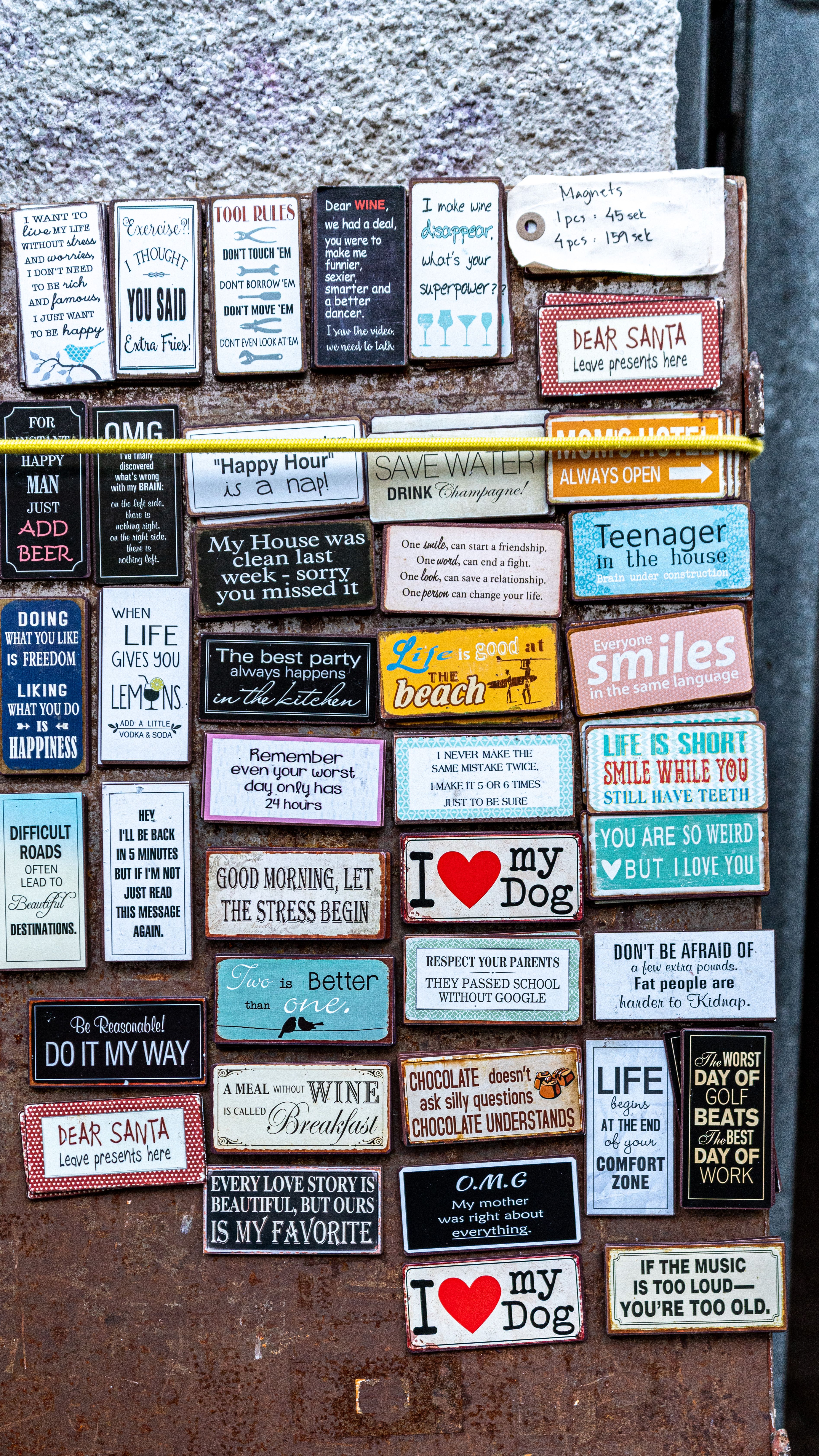 A diverse selection of humorous and motivational quote signs displayed on a wooden board.