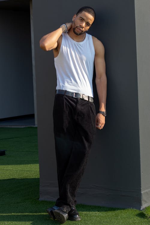 Model in a White Tank Top and Black Pants in the Yard