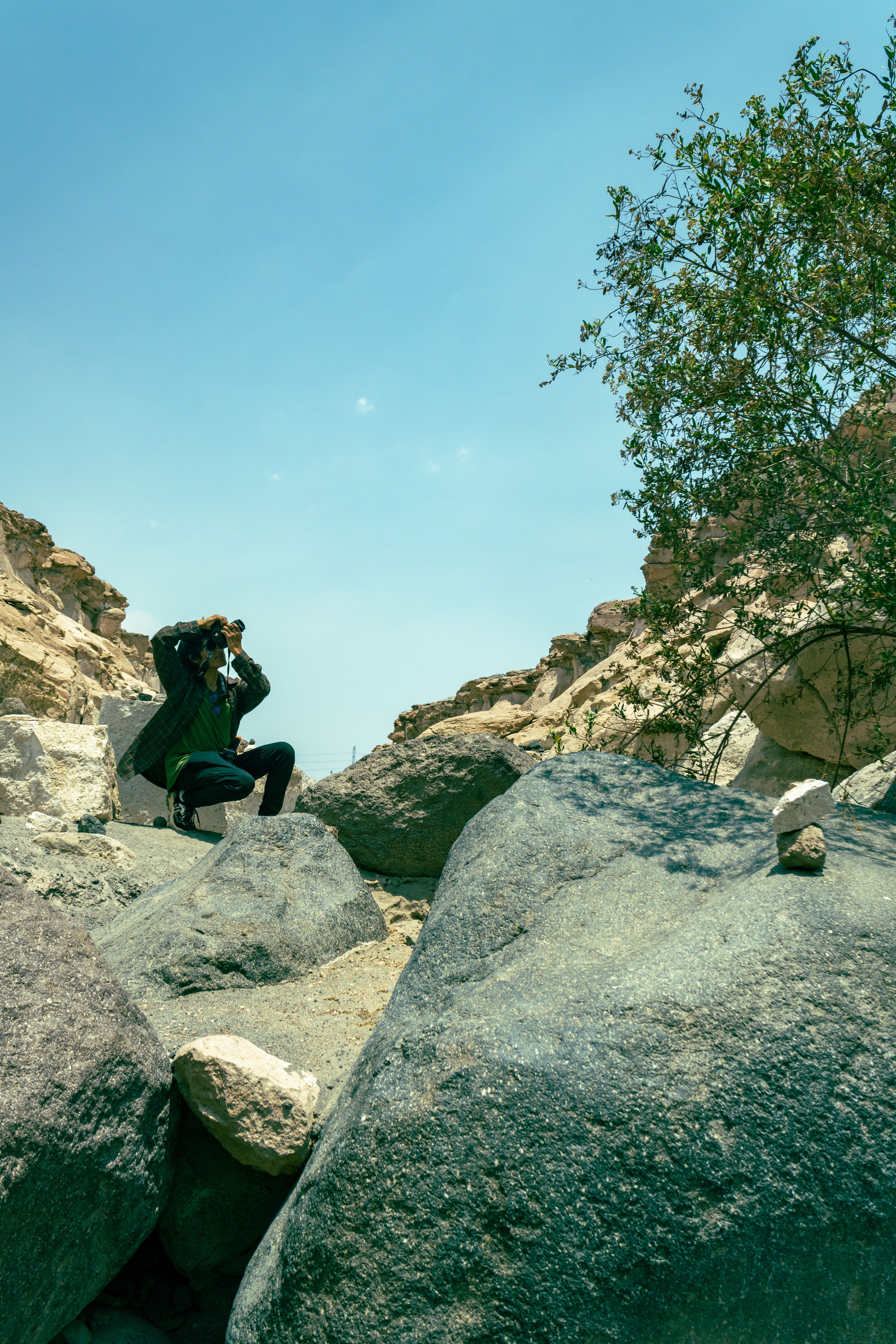 Person Sitting on Rocks and Taking Pictures · Free Stock Photo