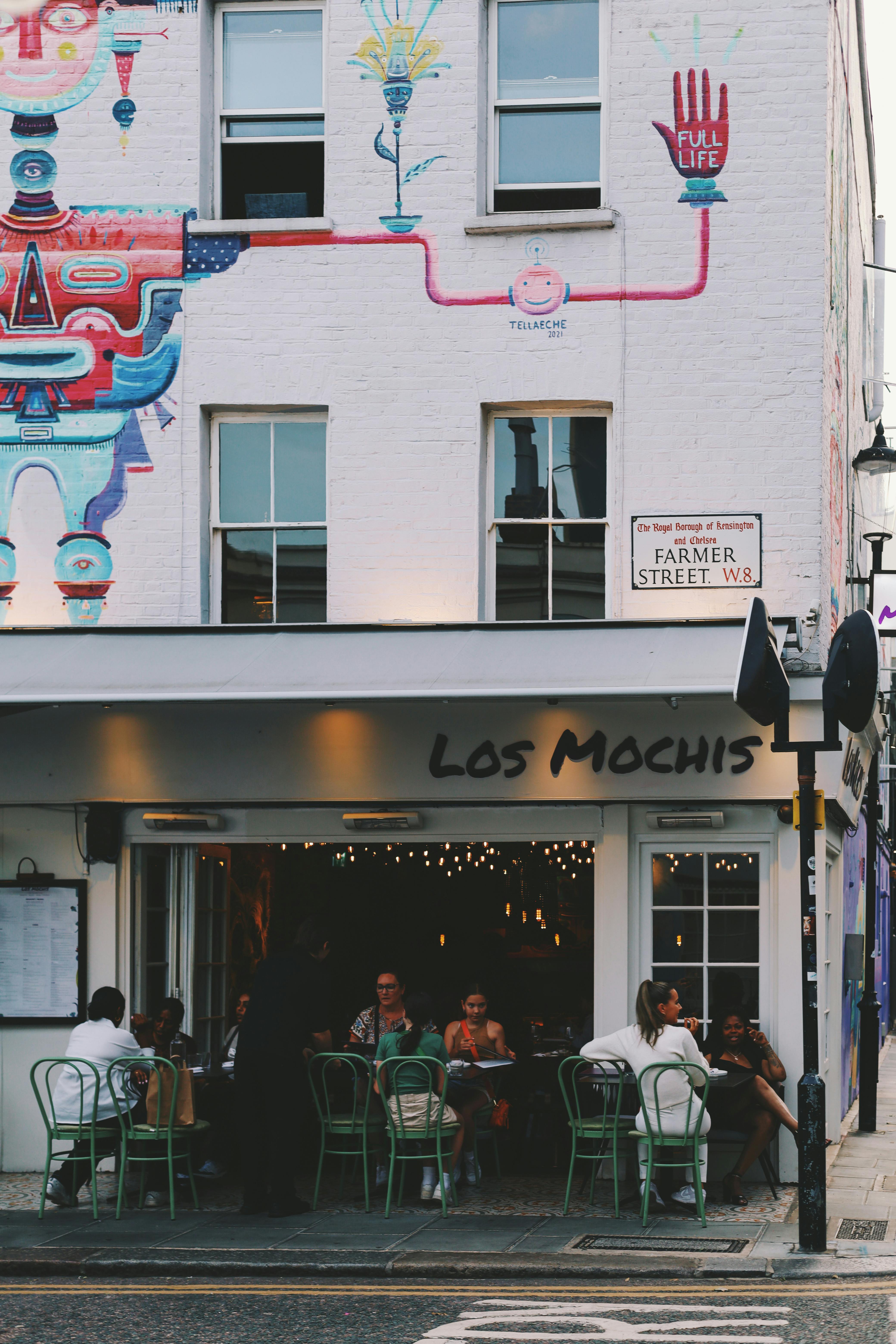 Colorful mural and lively dining scene at Los Mochis, a restaurant in Notting Hill, London.