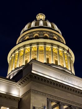 Stunning view of a classical Capitol dome, brightly illuminated at night, showcasing architectural elegance.