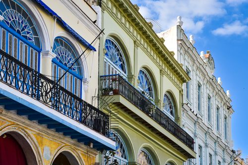 Free Charming colonial architecture with vibrant facades and arched windows in a sunny urban setting. Stock Photo