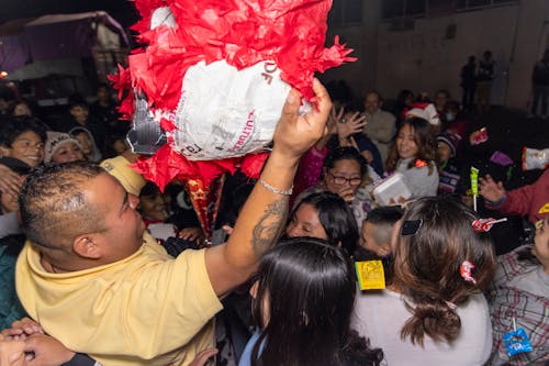 A Crowd Standing under a Pinata 