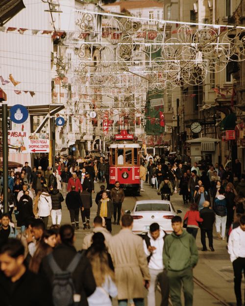 Free A lively view of İstiklal Avenue with a red tram surrounded by crowds in İstanbul, Türkiye. Stock Photo