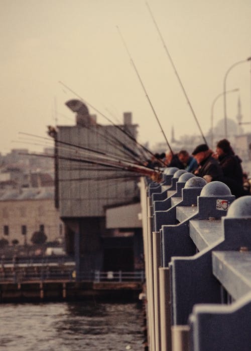 Group of Men on the Bridge Fishing in the Sea 