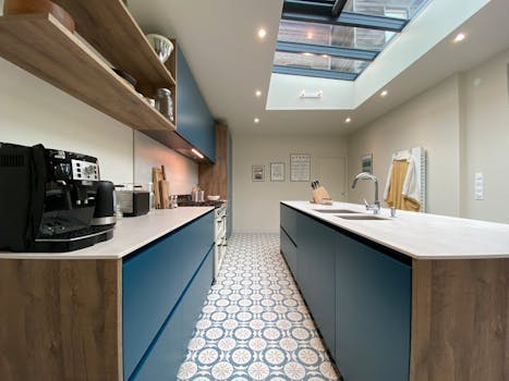 Contemporary kitchen design featuring blue cabinets, a skylight, and patterned floor tiles.