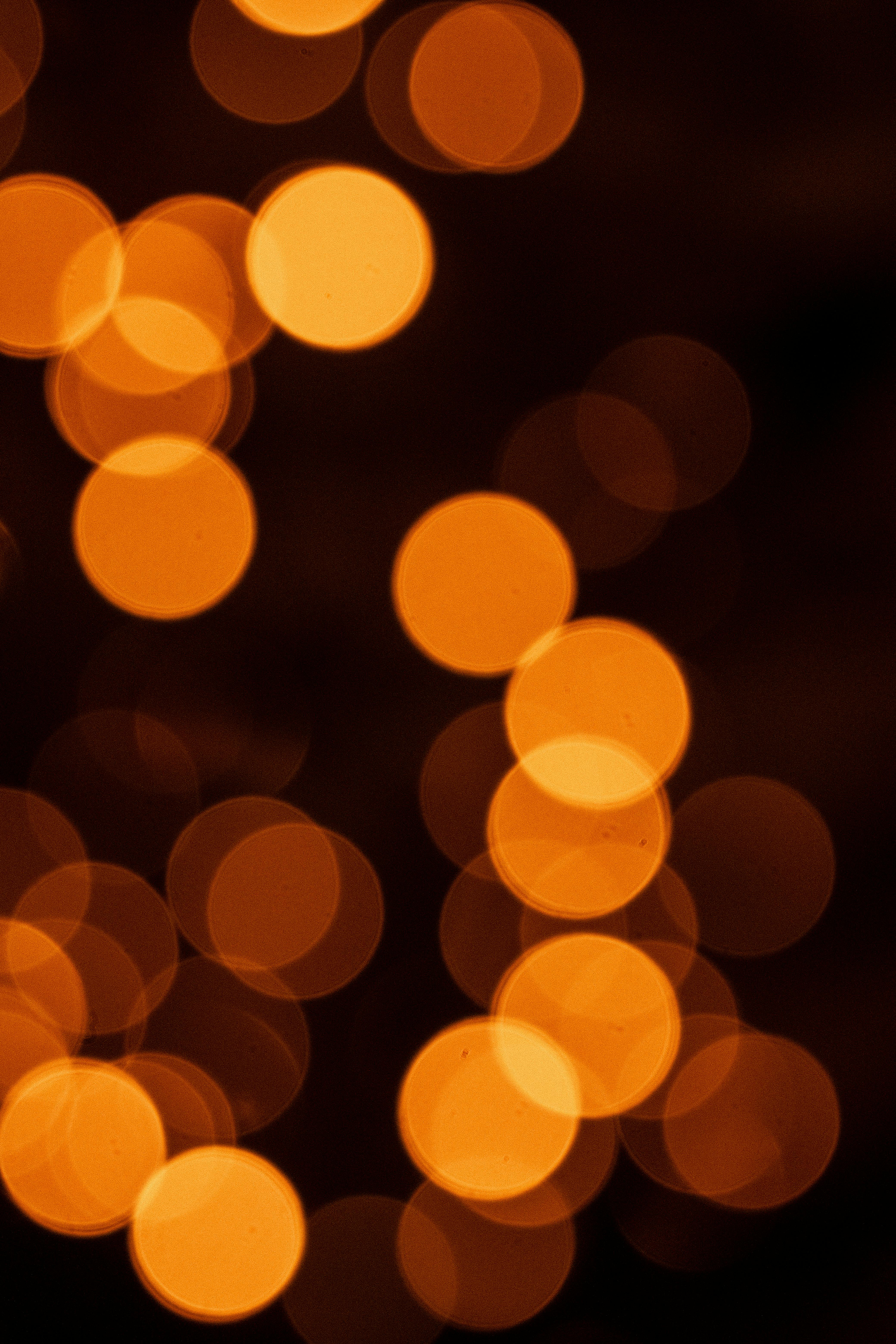 Abstract bokeh lights in warm tones ideal for festive backgrounds and decorations.