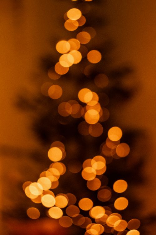 Free Blurred Christmas tree with bokeh lights creating a warm festive glow. Stock Photo