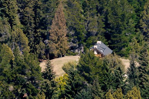 Free Aerial view of a secluded wooden cabin nestled in lush Patagonian forest, perfect for nature lovers. Stock Photo