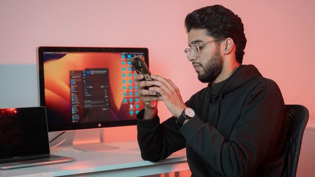 A man in glasses looking at his phone