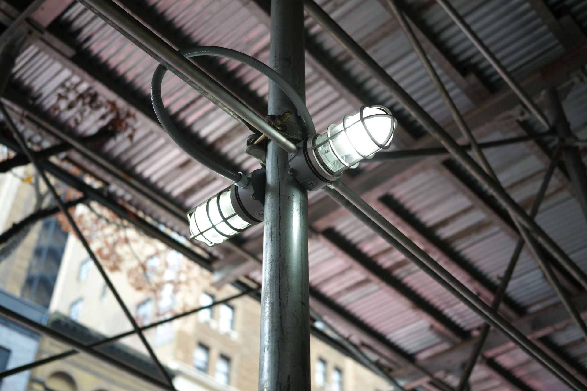 Low angle view of industrial lighting on scaffolding in an urban setting.