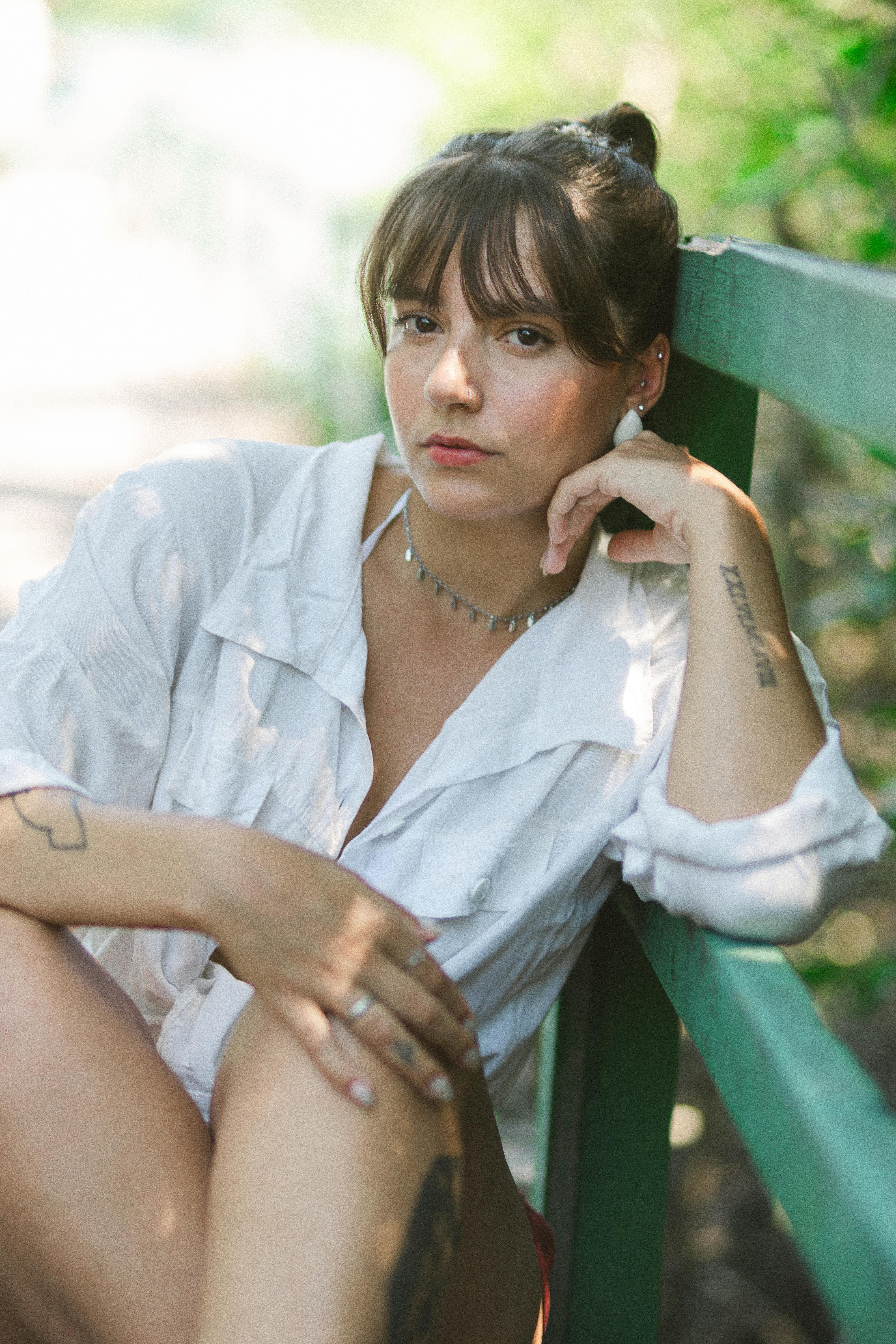 free photo of woman wearing a white shirt sitting on a bench