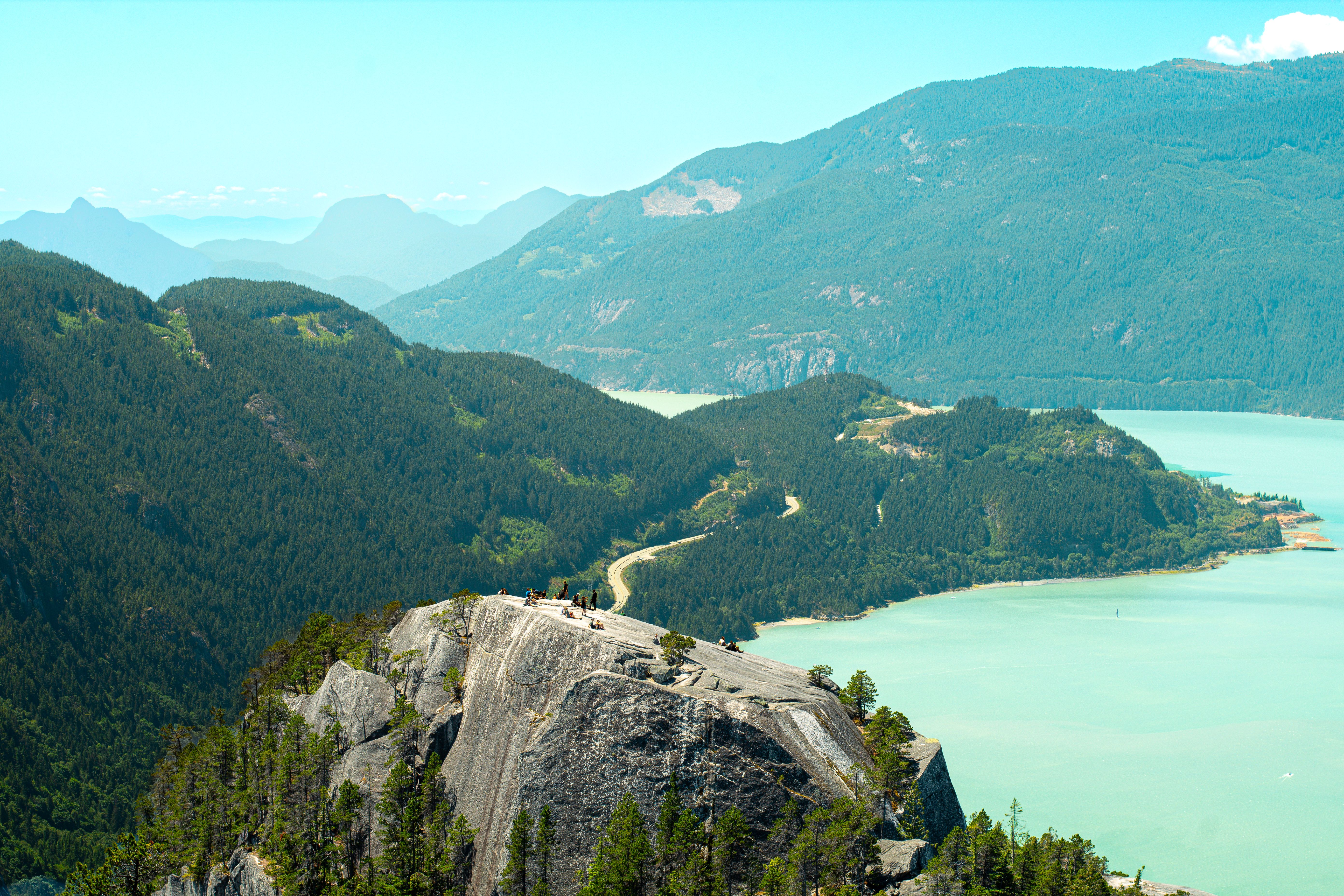 Stunning aerial view of green mountains, serene river, and clear sky.