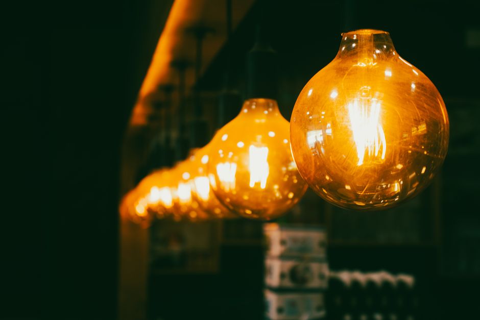 Myth-Busting Smart Bulbs vs Smart Switches: What Works Best in 2026 Close-up view of vintage light bulbs emitting a warm glow in a dim indoor setting.