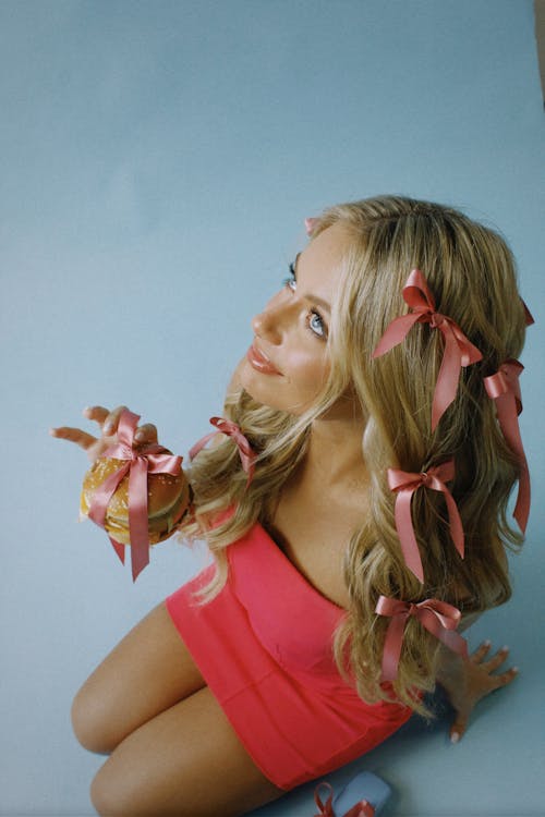 Blonde Model in Pink Dress Kneeling with Burger in Hand