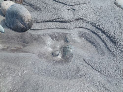 Free Natural close-up shot of wet rocks and textured sediment revealing earthy patterns. Stock Photo