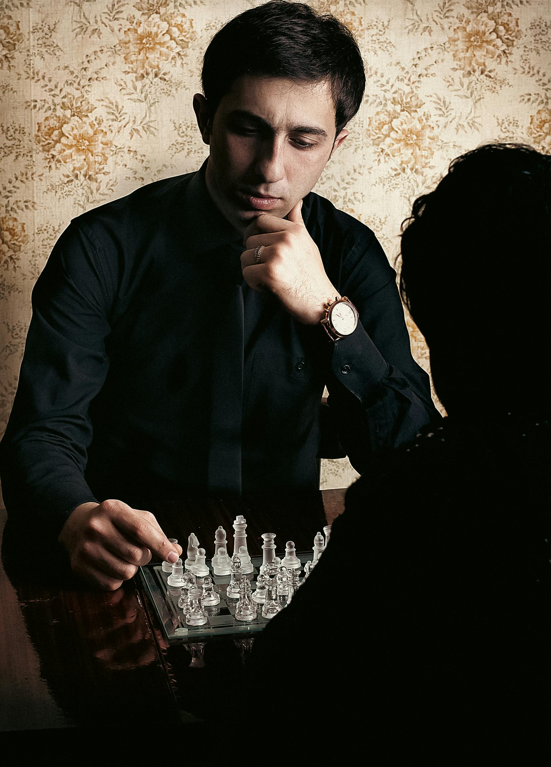 Adult man deeply focused while playing chess indoors, showcasing strategic thinking.