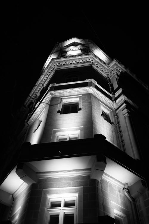 Free A low angle shot of an illuminated building facade with intricate architectural details at night. Stock Photo