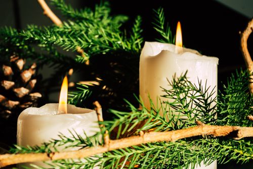 Free Beautiful candle arrangement with evergreen branches and pine cone, perfect for holiday decoration. Stock Photo