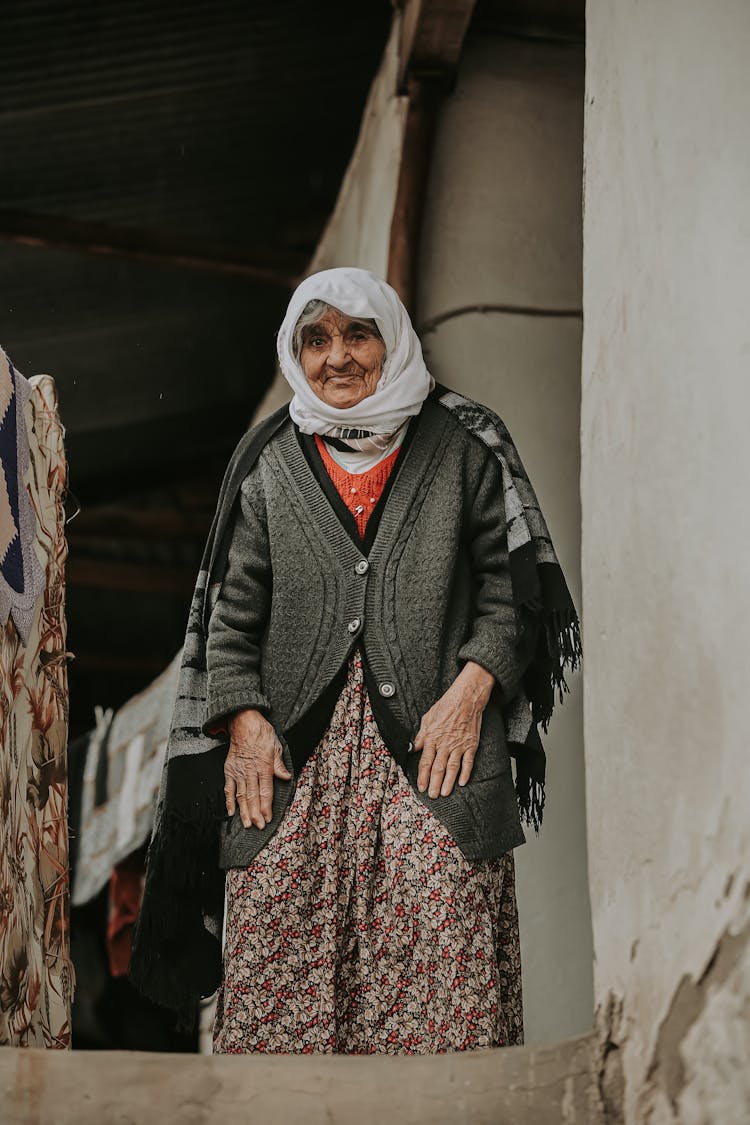 Elderly Woman With A Headscarf On Her Head Standing On The Steps