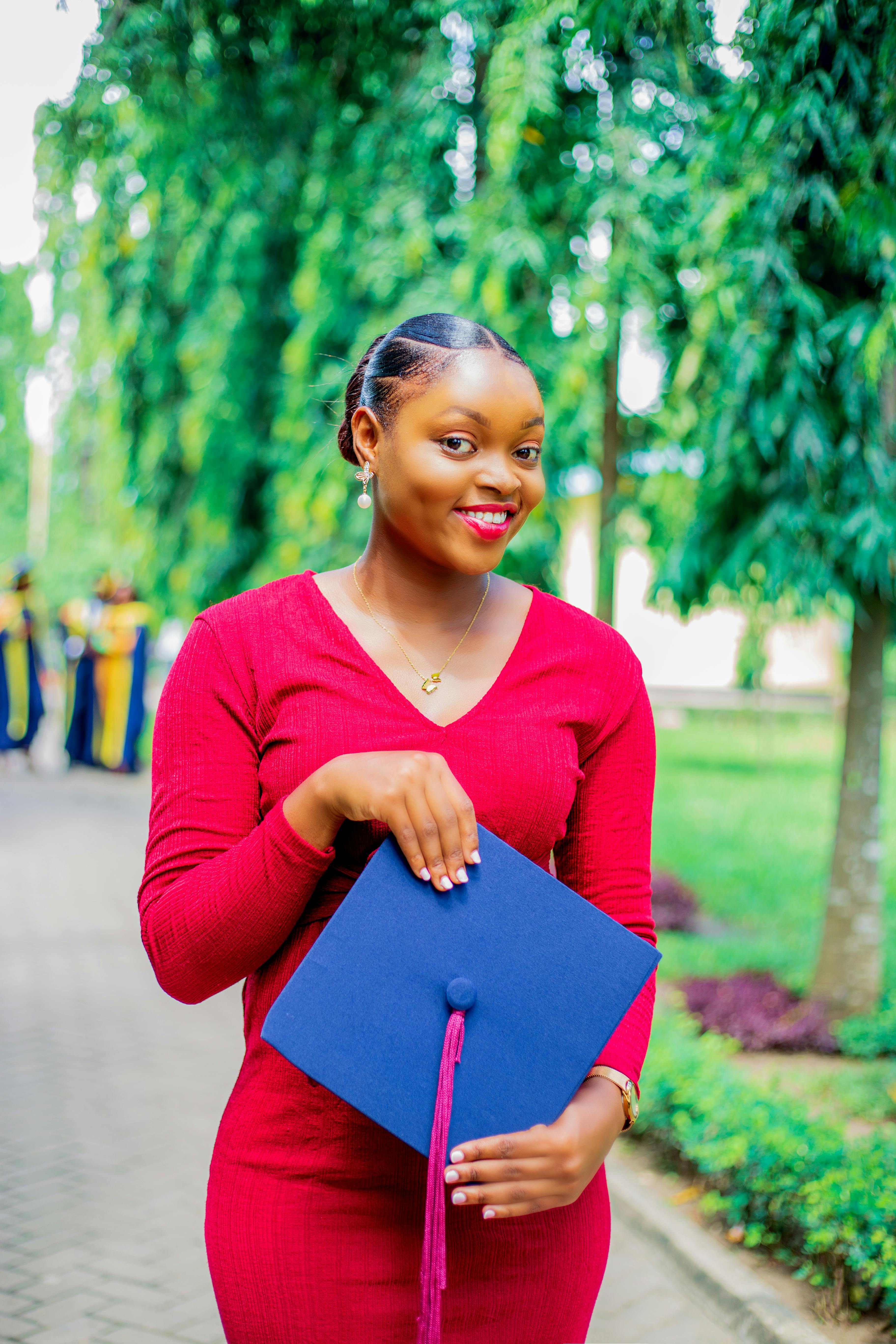 young woman posing with a graduation hat in hands