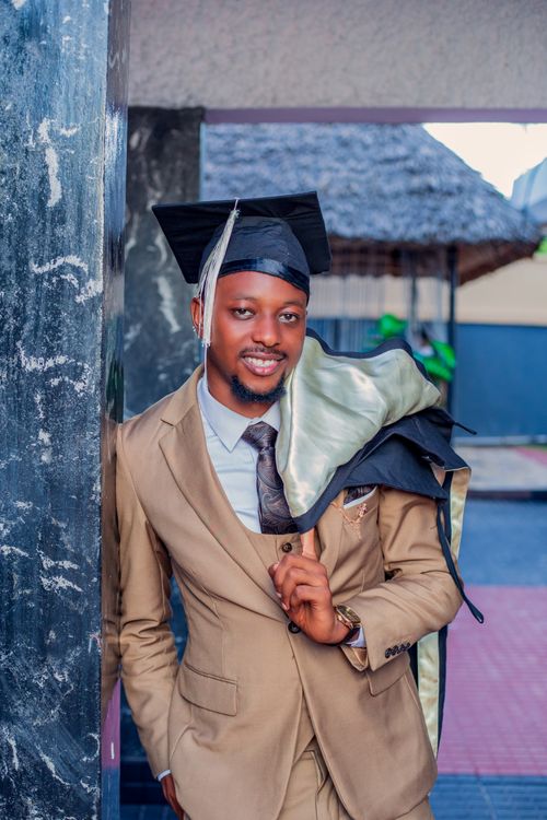 Free Smiling graduate in a suit and cap, posing outdoors with confidence. Stock Photo
