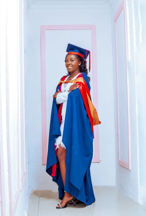 Smiling Graduate in Mortarboard and Blue Gown over White Dress Free Stock Photo Smiling Graduate in Mortarboard and Blue Gown over White Dress Free Stock Photo