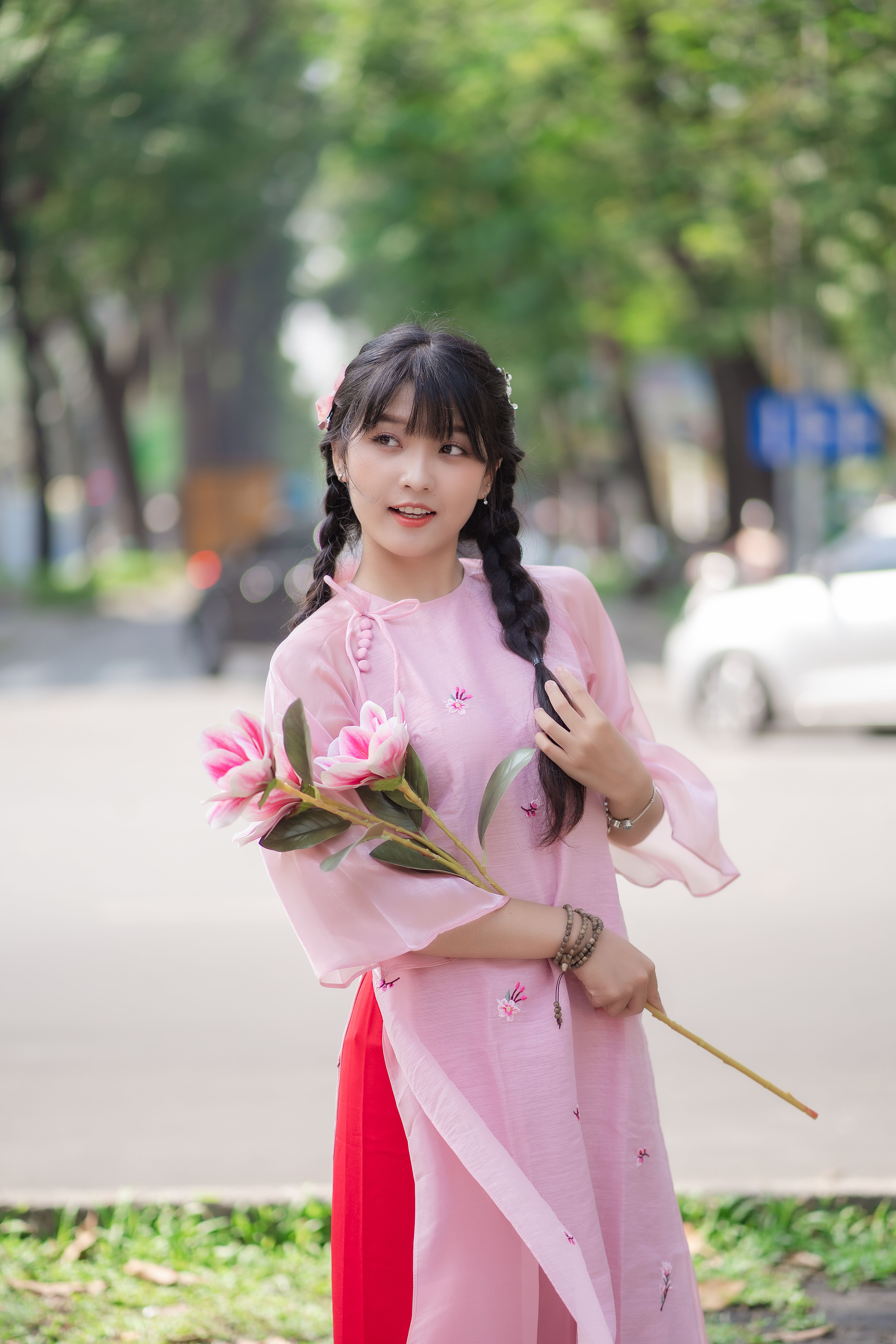 Brunette in Pink Dress Posing with Flowers · Free Stock Photo