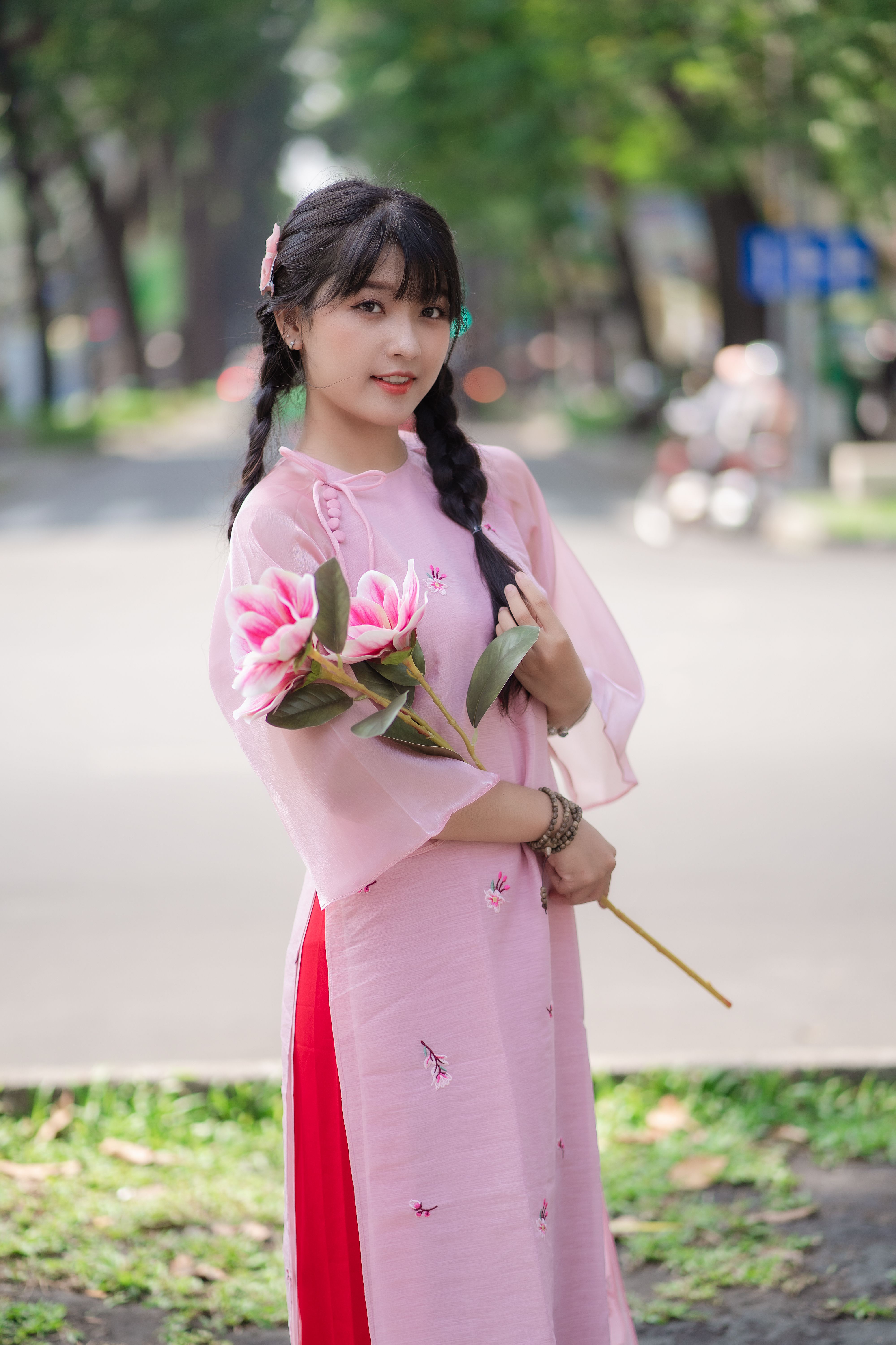 Brunette in Pink Dress Posing with Flowers · Free Stock Photo