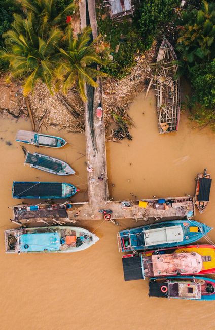 Discover the vibrant fishing scene in Chukai with colorful boats docked along a tropical shoreline.