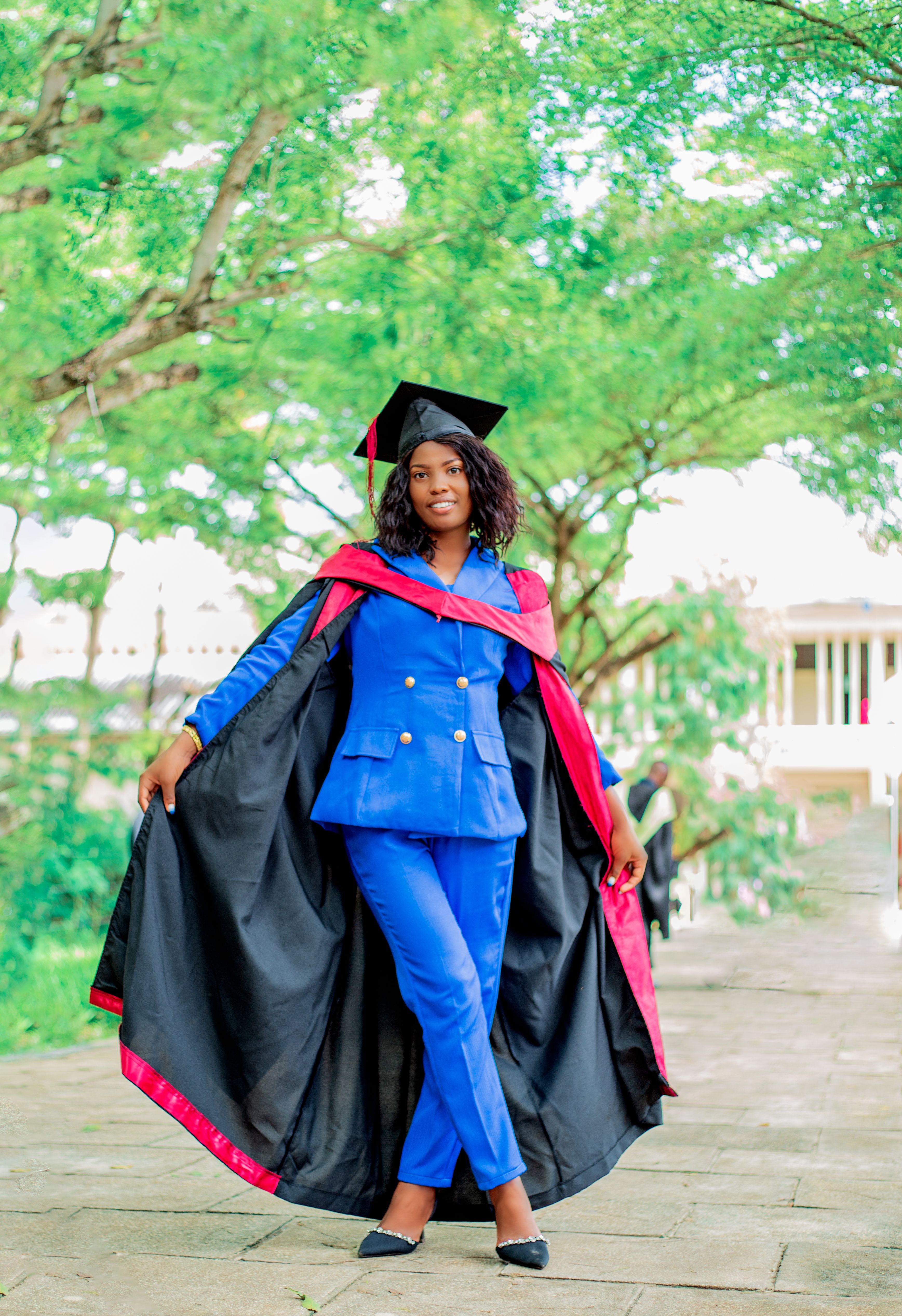 Elegant Young Woman Posing in Graduation Gown and Cap · Free Stock Photo