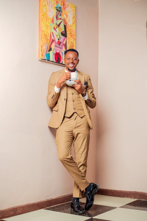 Smiling Man in a Suit Holding a Tea Cup