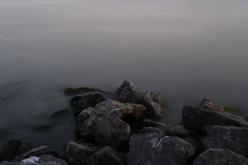 Free Moody shoreline scene in Istanbul featuring rocks and calm waters at twilight. Stock Photo