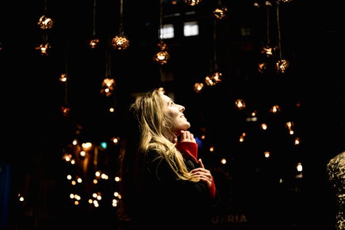 Blonde Woman in Front of a Christmas Tree in the Evening 