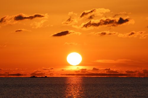 Free A breathtaking ocean sunset with a vibrant orange sky, perfect for serene backgrounds. Stock Photo
