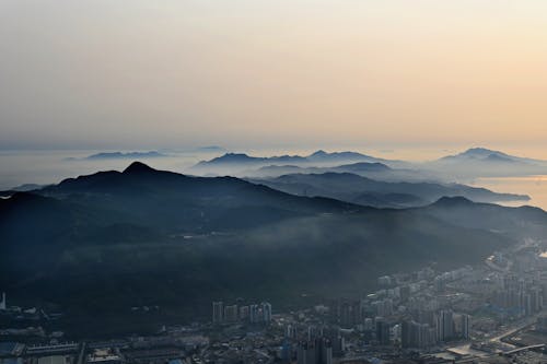 Aerial Panorama of a City and Mountains in Fog