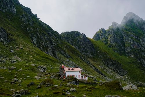 Free A solitary house nestled in misty mountain terrain, perfect for nature enthusiasts. Stock Photo