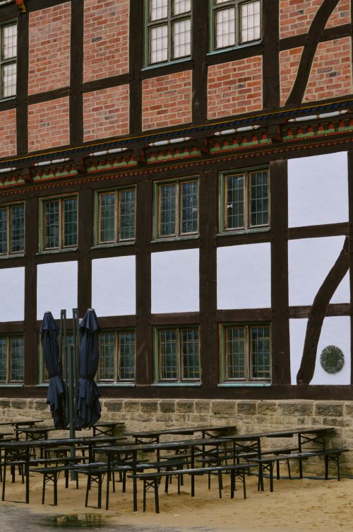 Free Traditional half-timbered building with tables and chairs outdoors, showcasing classic architectural style. Stock Photo