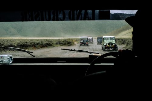 Free Scenic off-road journey with multiple Land Cruisers on a dirt road, viewed from a windshield perspective. Stock Photo