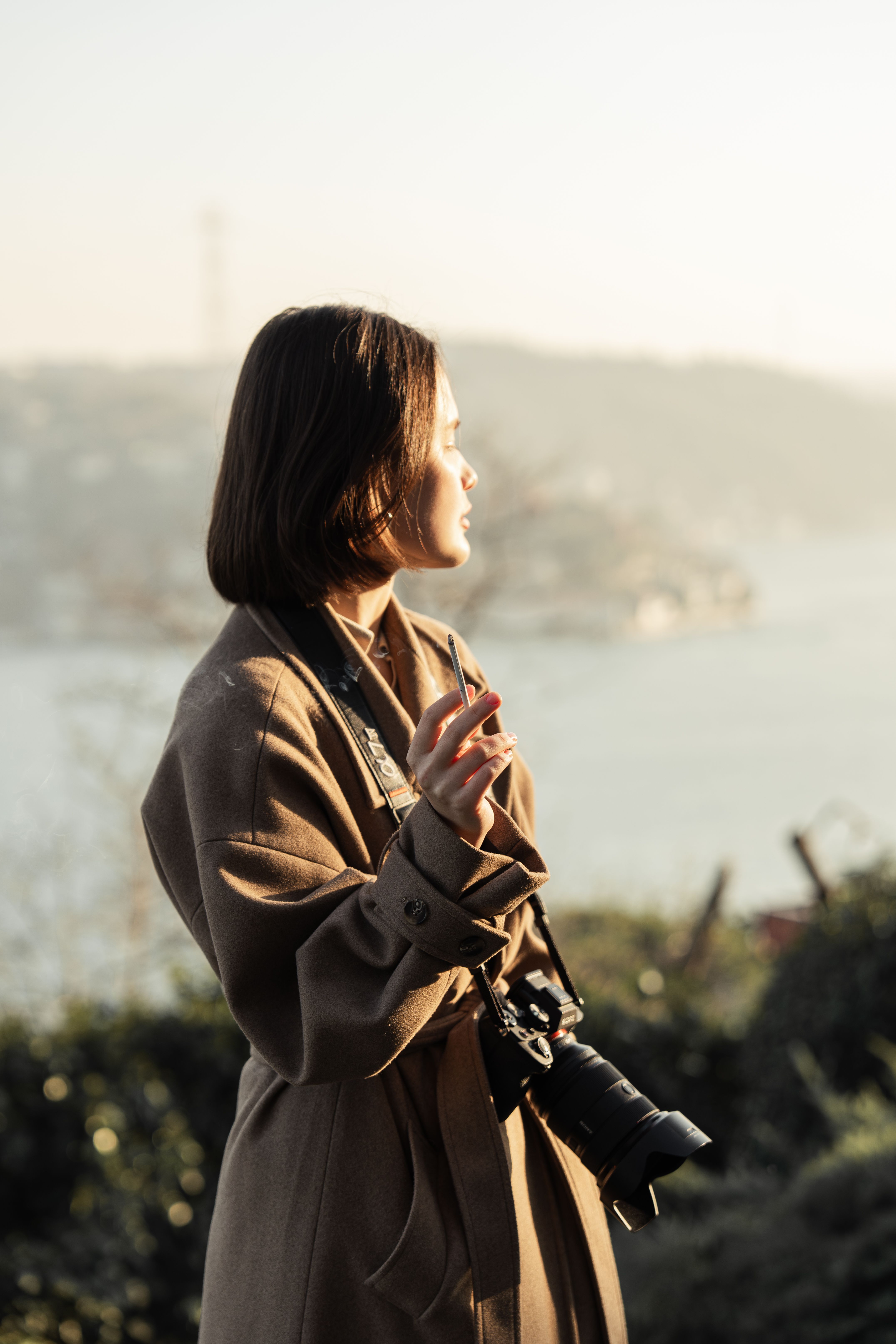 Woman with Camera Hang on Neck Holding Cigarette · Free Stock Photo