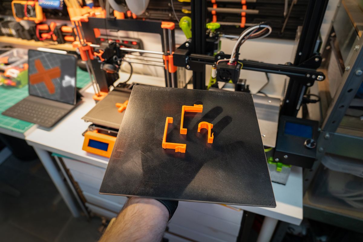 Close-up of a 3D printer and printed parts in a modern workshop setting