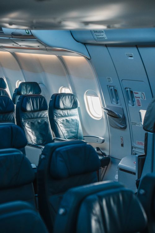 Free Interior view of an airplane cabin featuring empty seats and natural daylight. Stock Photo