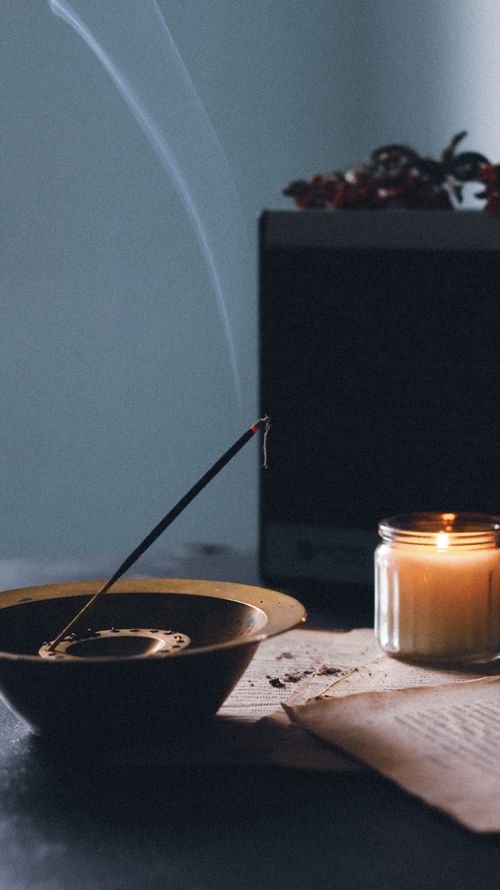 Free A tranquil setup featuring a candle and incense stick creating a calming ambiance indoors. Stock Photo