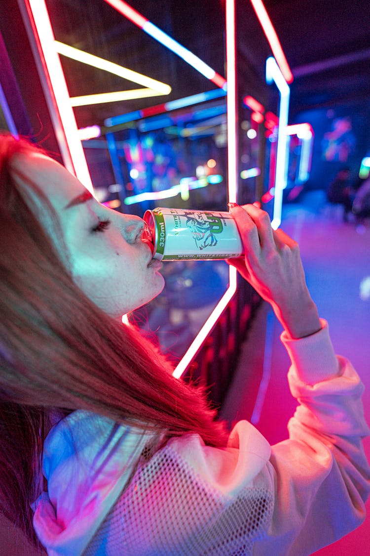 Woman Drinking Soda In Illuminated Bar